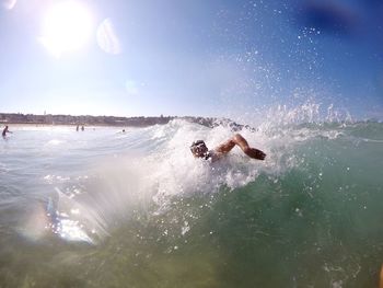 Man surfing in sea against sky