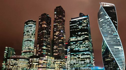 Low angle view of illuminated buildings against sky at night