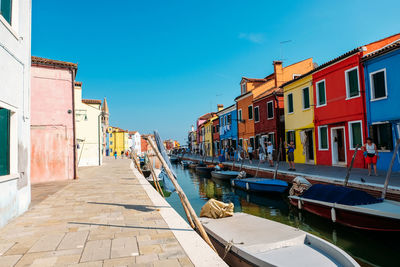 Canal amidst buildings against sky in city