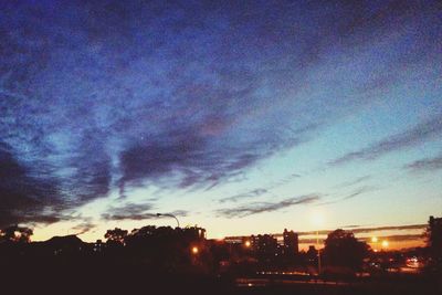 View of city lit up at sunset