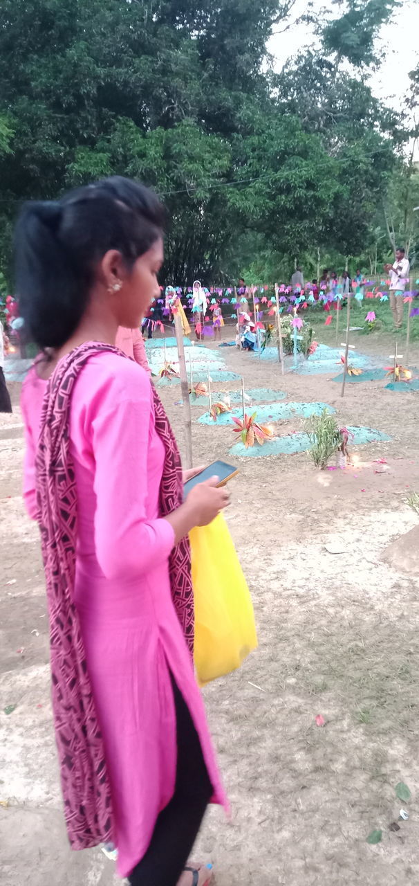 SIDE VIEW OF WOMAN STANDING ON PINK FLOWER