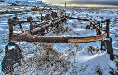 Abandoned boat moored on sea against sky