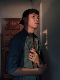 Young man standing against wall