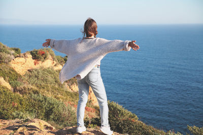 Rear view of man standing by sea