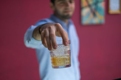 Midsection of man offering drink