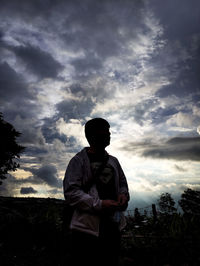 Silhouette man standing against sky