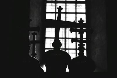 Silhouette of people on window sill in darkroom