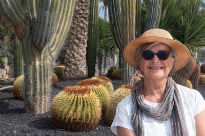 Portrait of smiling senior woman against plant