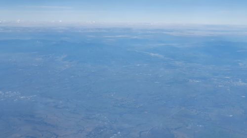 Aerial view of landscape against blue sky