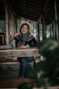 Full length portrait of woman sitting outdoors