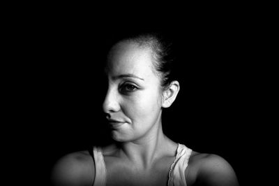 Portrait of woman against black background