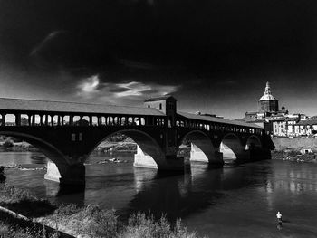 Arch bridge over river against sky