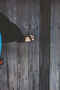 Low section of man standing on wooden floor