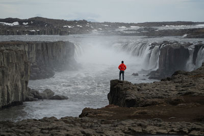 Rear view of man standing on rock