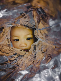 Close-up portrait of cute baby girl amidst foil