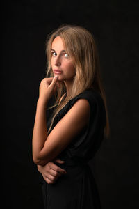 Portrait of a beautiful young woman over black background