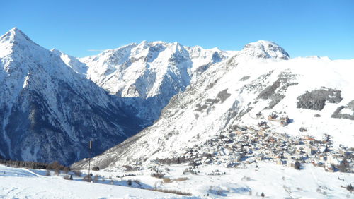 Scenic view of snowcapped mountains against clear blue sky