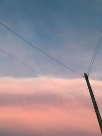 Low angle view of silhouette electricity pylon against sky during sunset