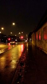 Road passing through illuminated city at night