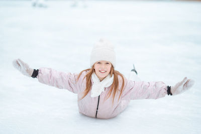 Portrait of smiling young woman standing on snow