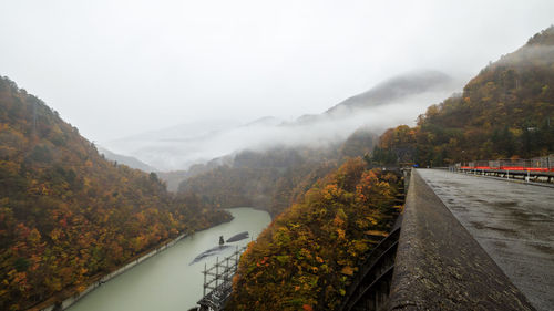 Road amidst mountains against sky during autumn