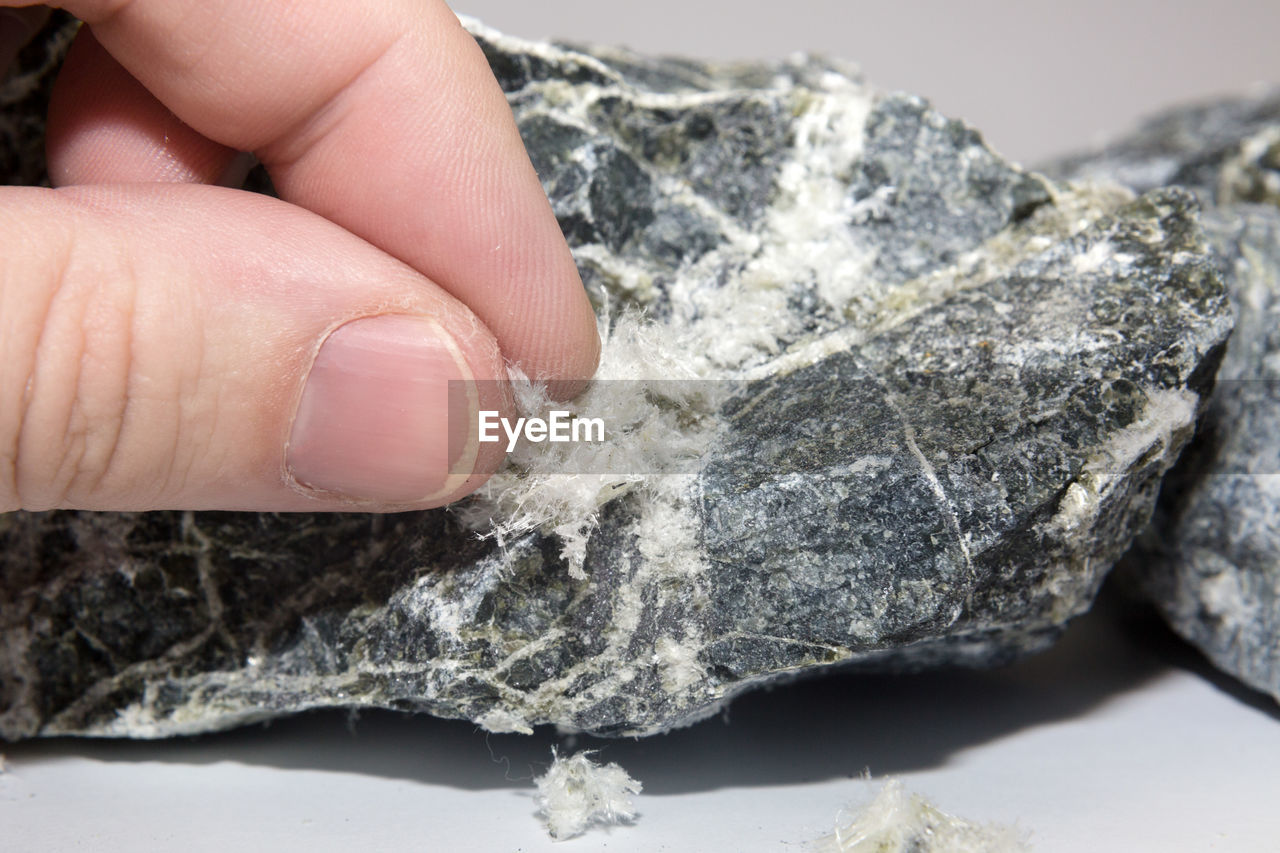 Asbestos mineral fiber human fingers, close-up. macro photography.