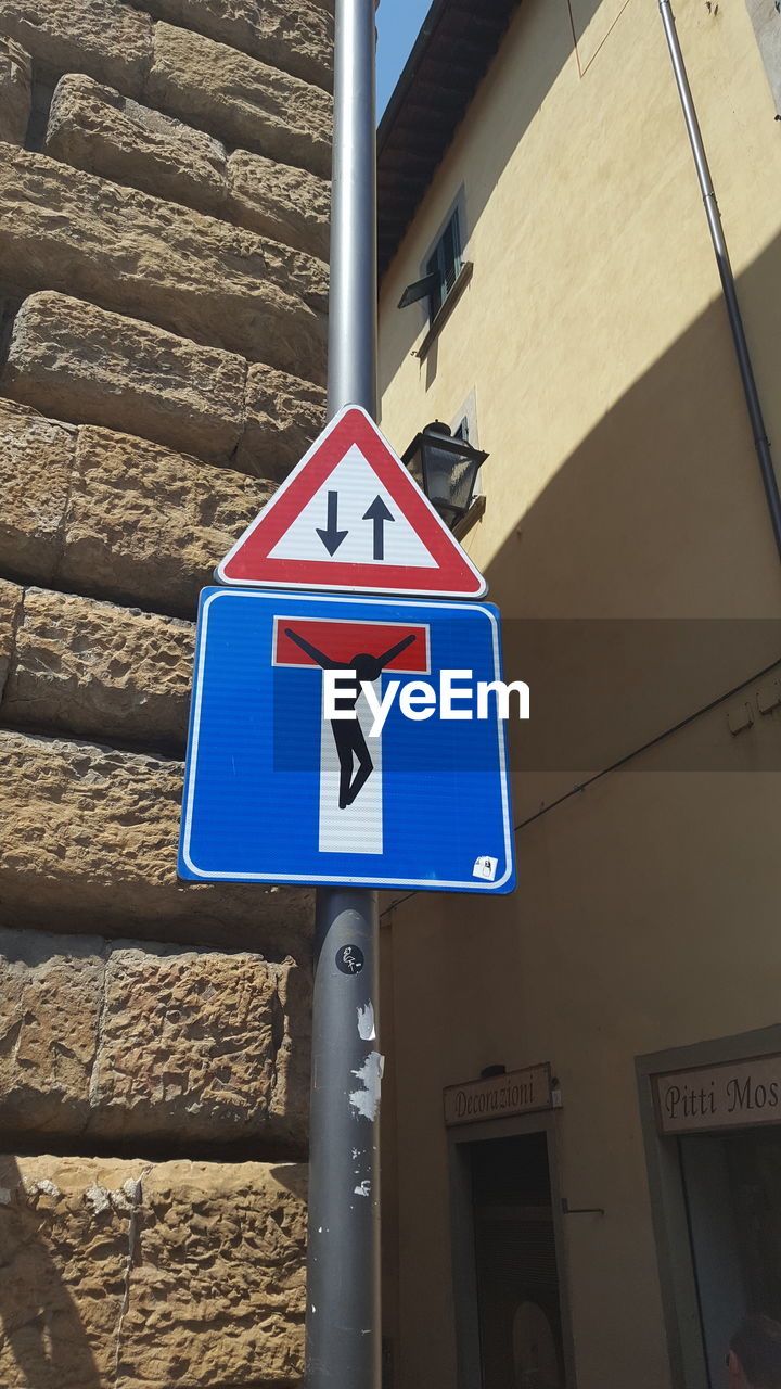 LOW ANGLE VIEW OF ROAD SIGN AGAINST BLUE WALL