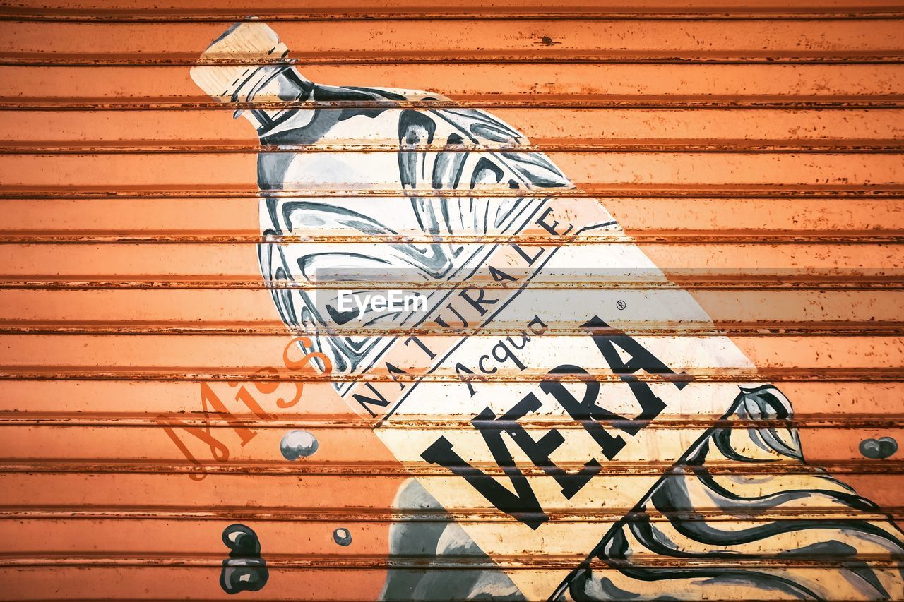 CLOSE-UP OF METAL WALL WITH SHADOW ON TEXTURED SURFACE