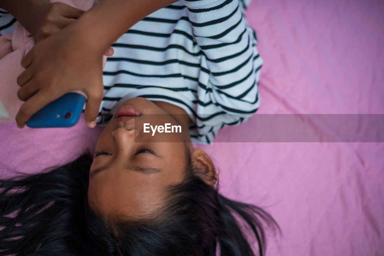 HIGH ANGLE VIEW OF BOY SLEEPING IN BED