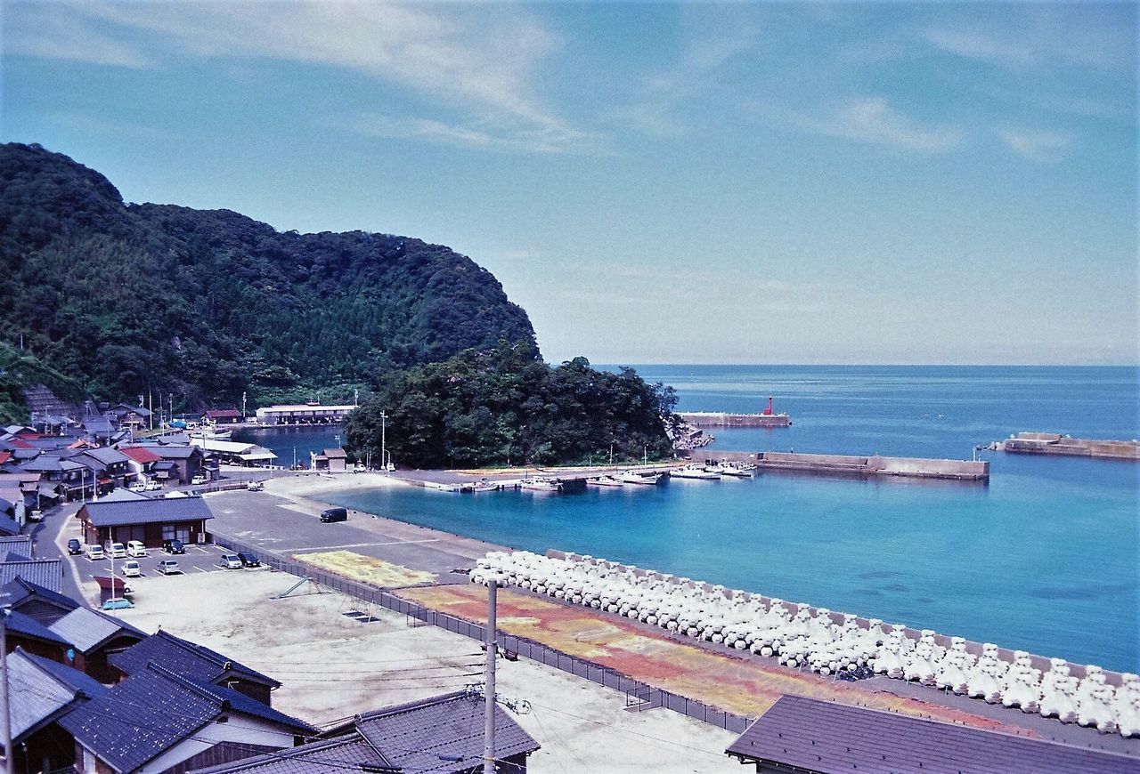 SCENIC VIEW OF SEA AND MOUNTAINS AGAINST BLUE SKY