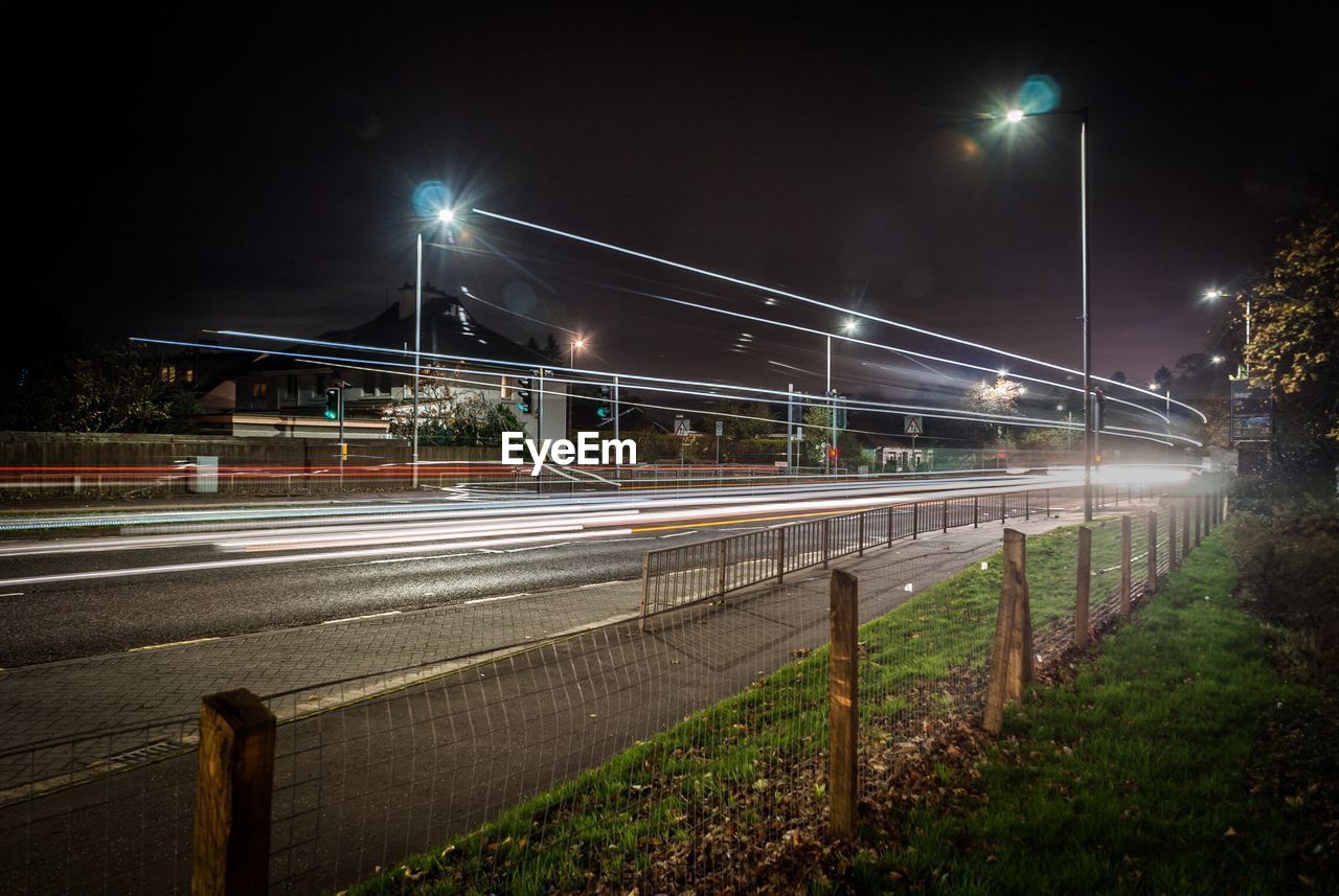 Light trails on road against sky at night