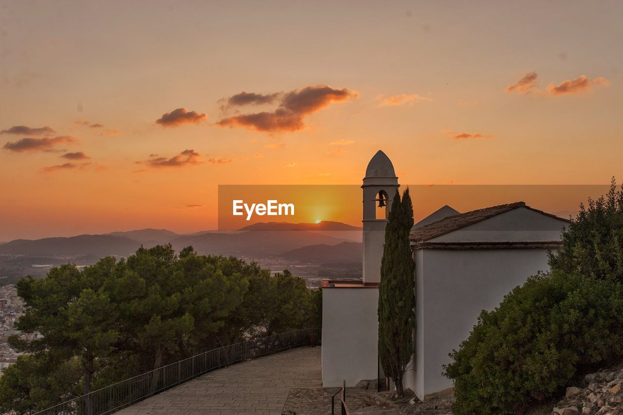 Scenic view of building against sky during sunset