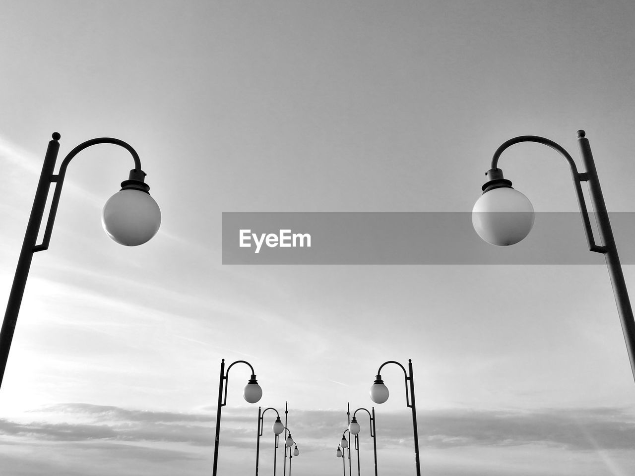 LOW ANGLE VIEW OF STREET LIGHT HANGING AGAINST SKY