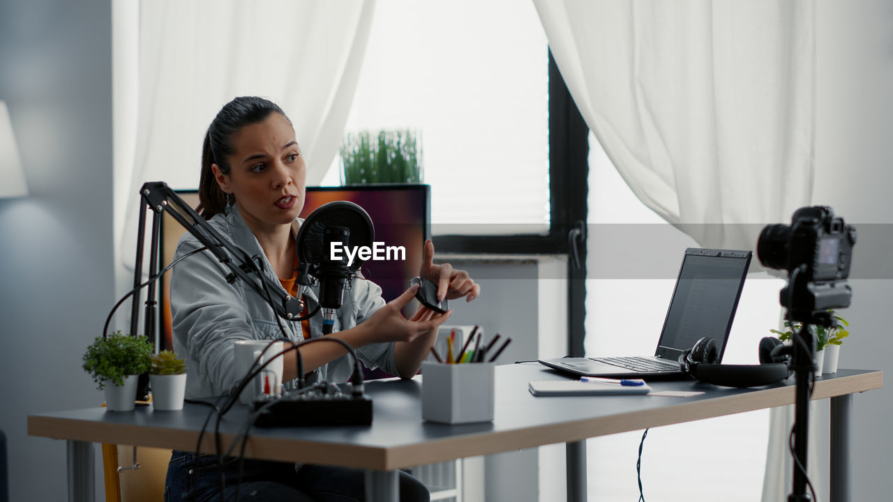 portrait of young woman using laptop at home