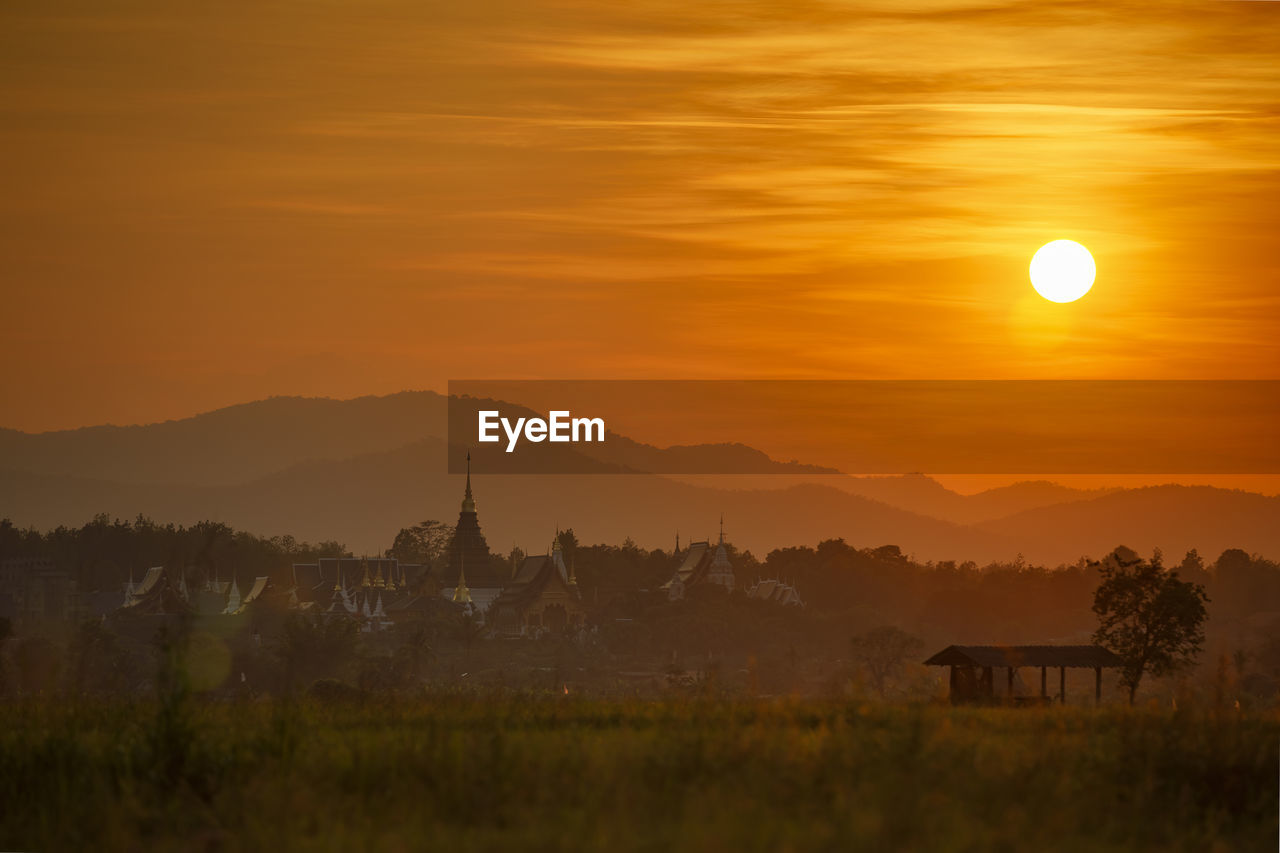 Scenic view of landscape against orange sky