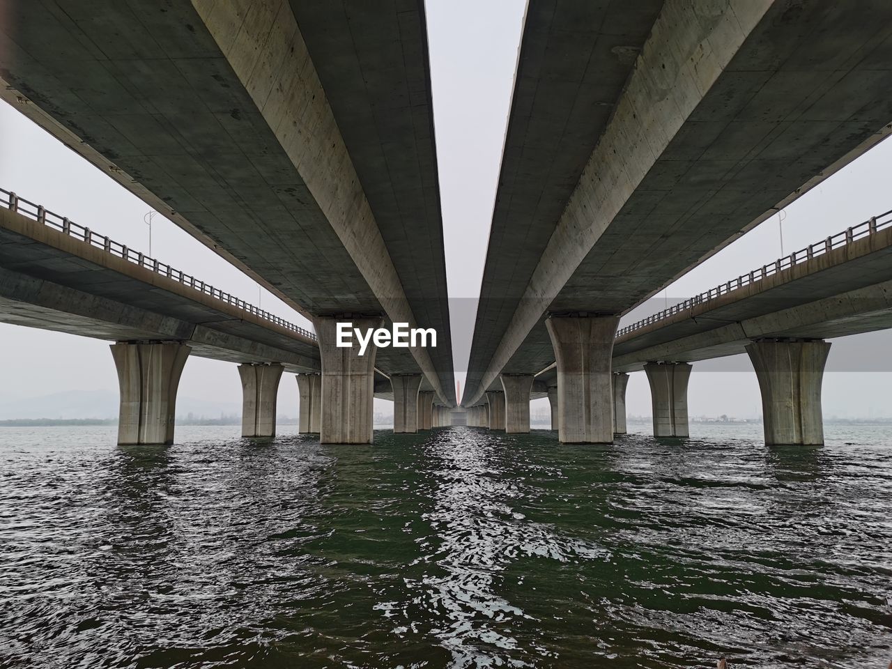 Low angle view of bridge over river against sky