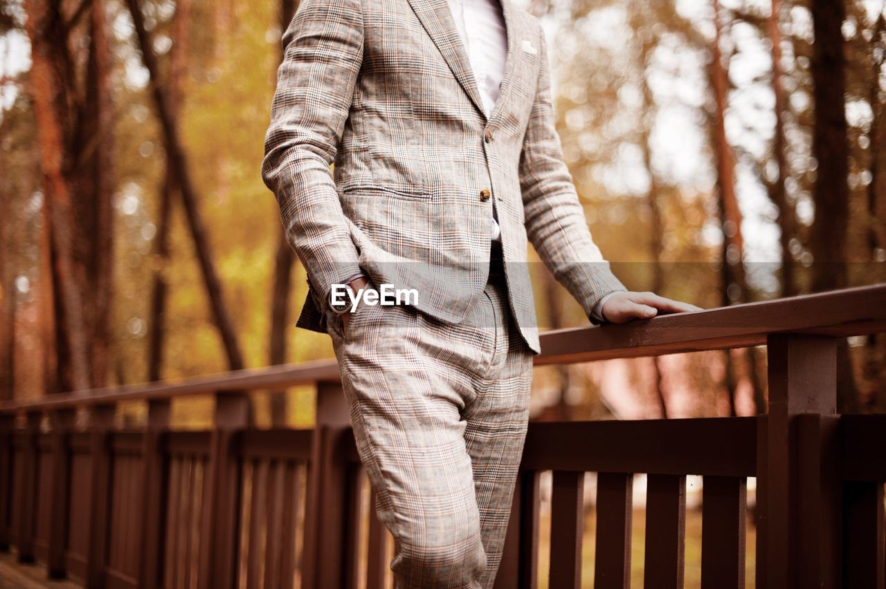 Midsection of well-dressed man standing in park