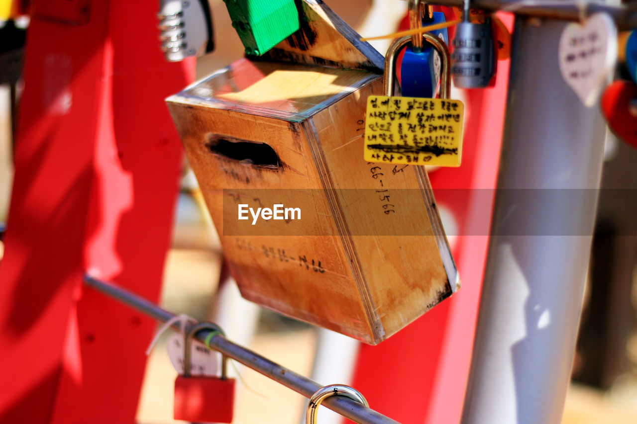 CLOSE-UP OF LOVE PADLOCKS HANGING ON METAL