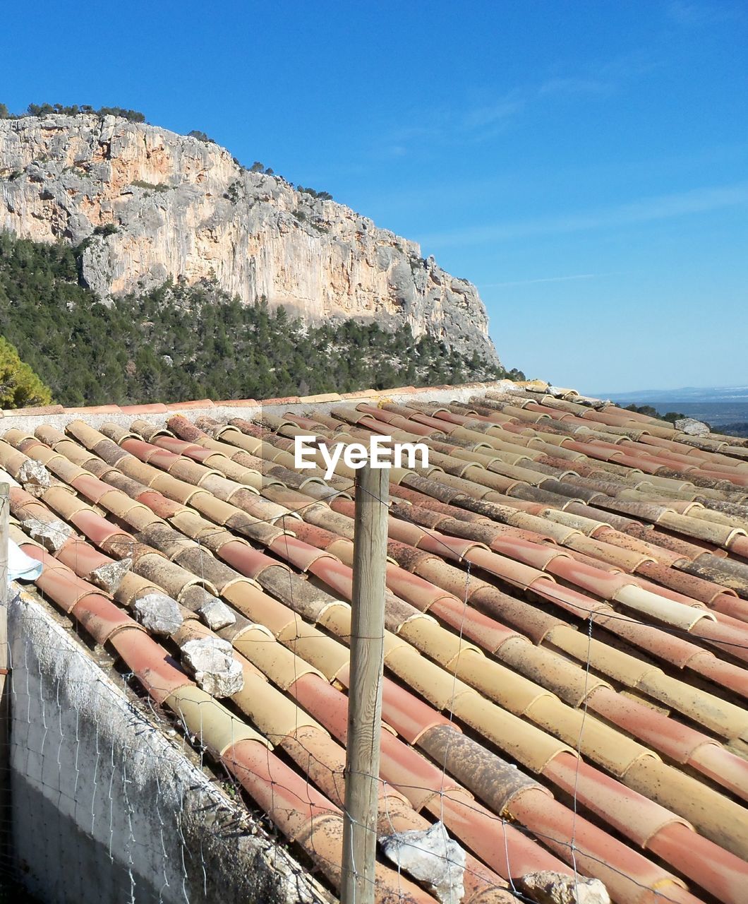 STACK OF ROCKS ON ROOF AGAINST SKY