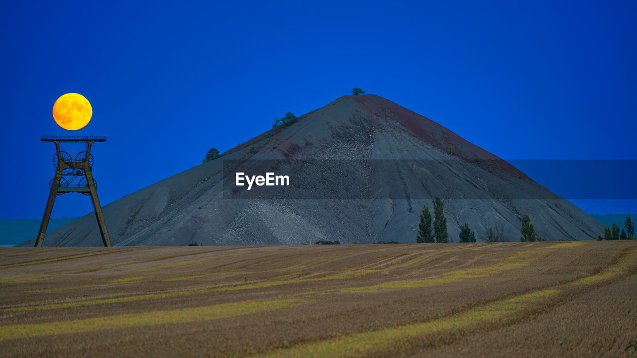 scenic view of desert against blue sky