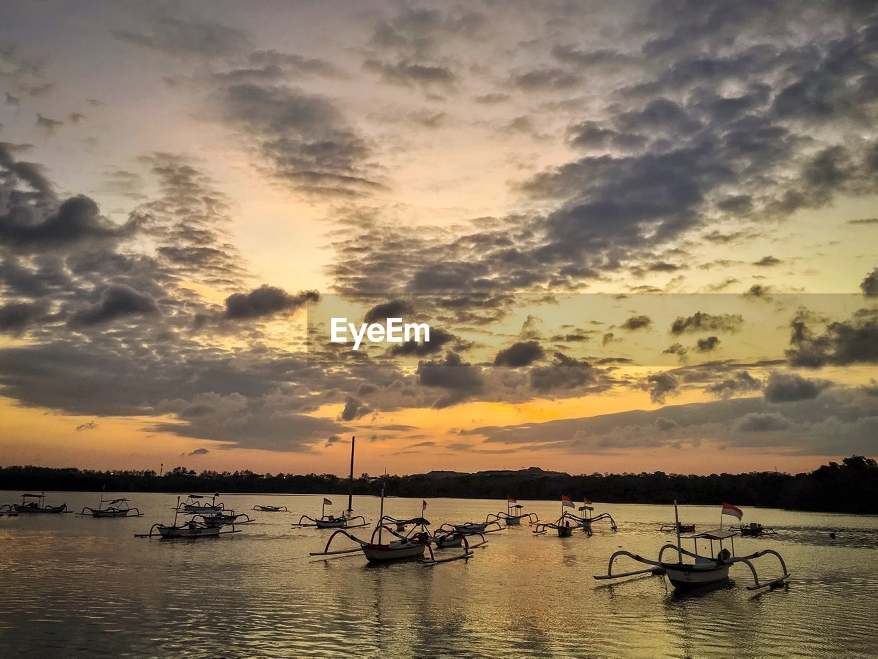 SILHOUETTE BOATS MOORED IN SEA AGAINST SKY AT SUNSET