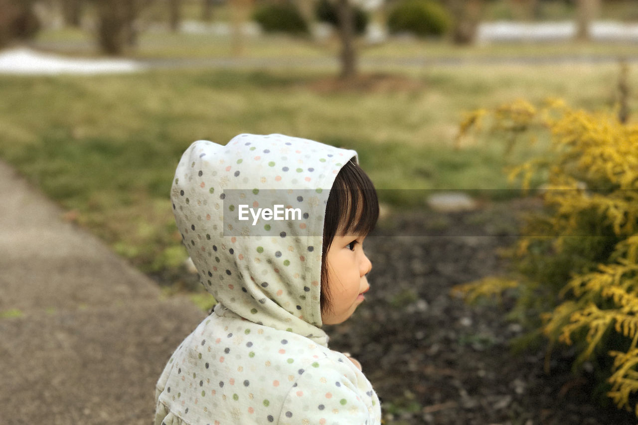 Portrait of a girl looking away against grass