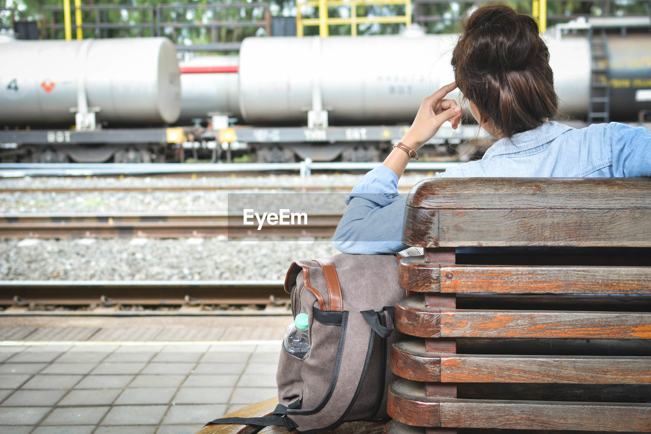 Woman sitting on railway station platform