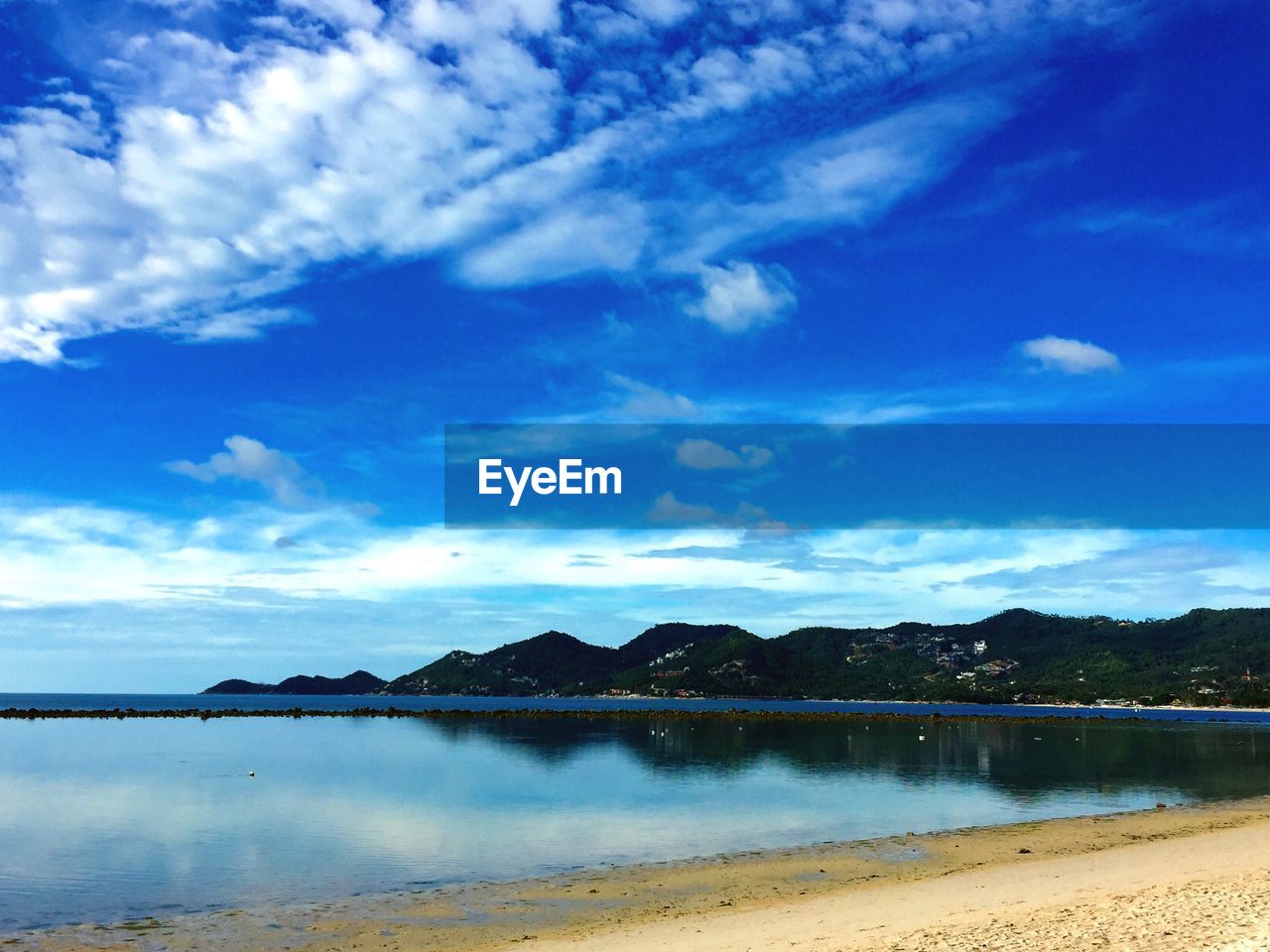 SCENIC VIEW OF LAKE BY MOUNTAINS AGAINST BLUE SKY