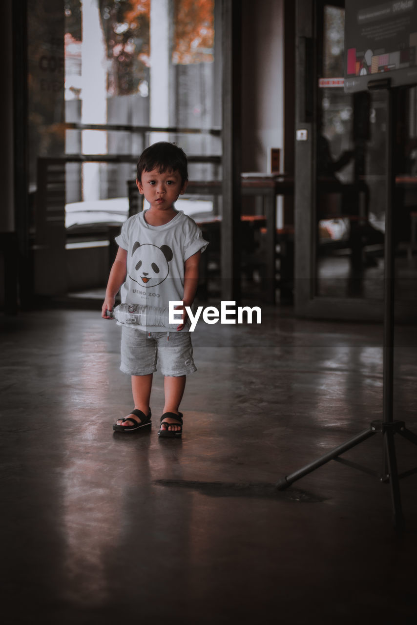 FULL LENGTH PORTRAIT OF BOY STANDING ON FLOOR