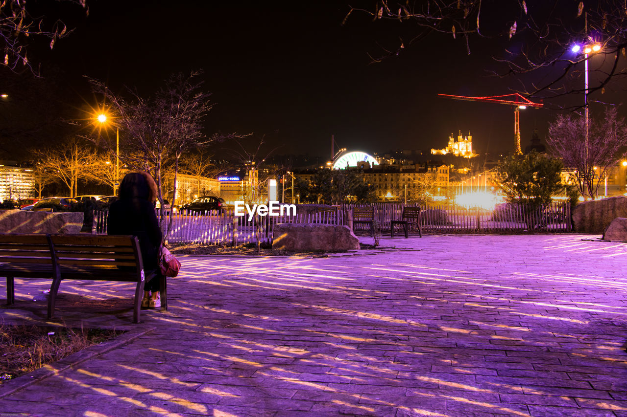 MAN ON SNOW COVERED CITY AT NIGHT