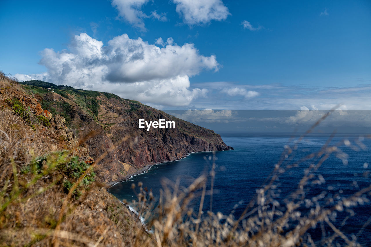 Scenic view of sea and mountains against sky