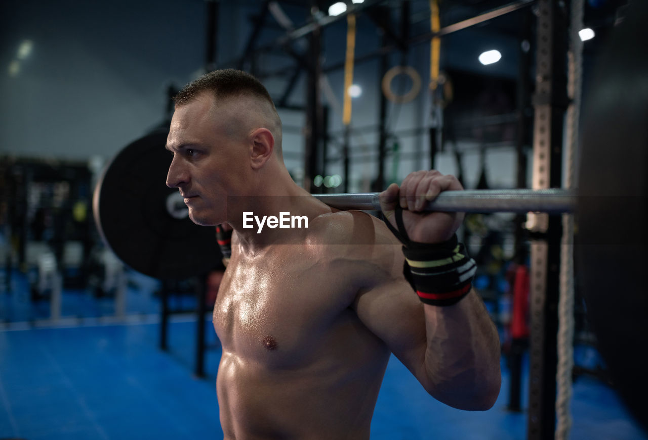 Strained sportsman exercising in gym