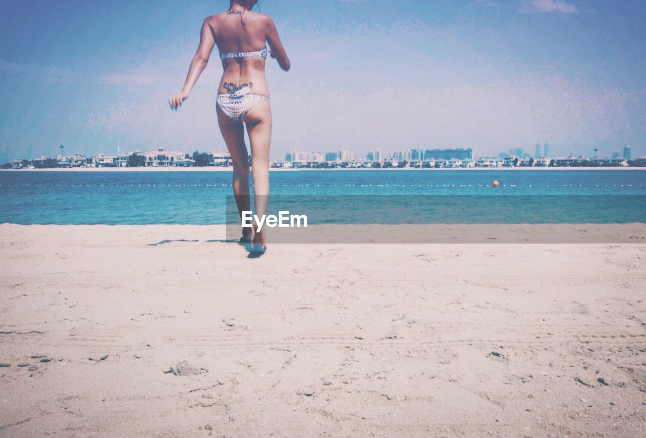 REAR VIEW OF WOMAN ON BEACH