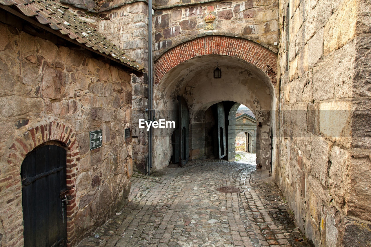 Empty footpath amidst old buildings